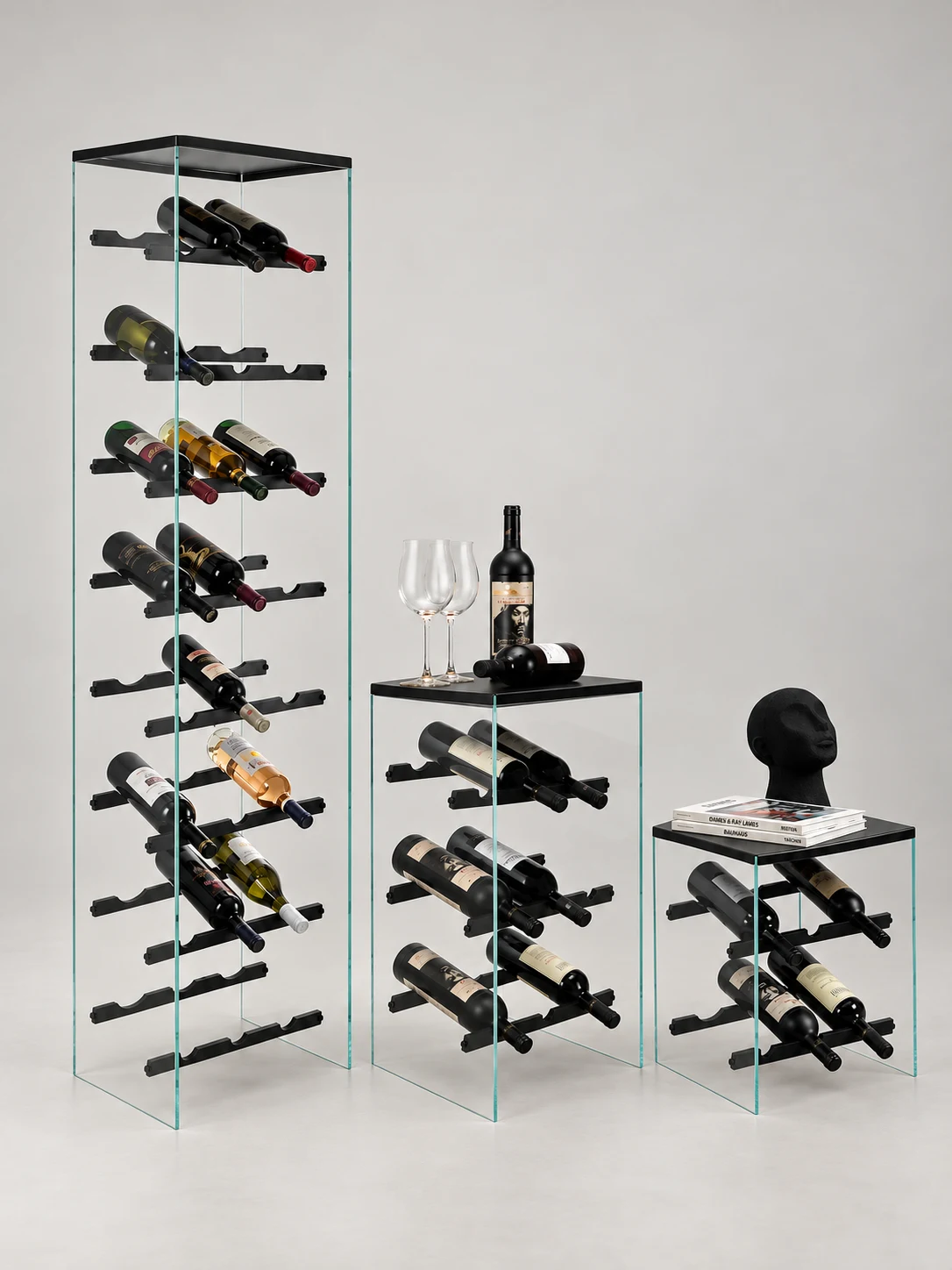 Die drei Weinregale von NUMEN STUDIOS nebeneinander: groß, mittel und klein, aus klarem Glas und schwarzem Metall